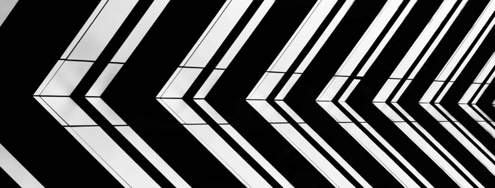 Fachada arquitectónica en blanco y negro con líneas en chevron