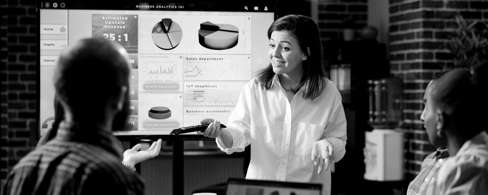 Equipo revisando resultados en una pantalla, blanco y negro